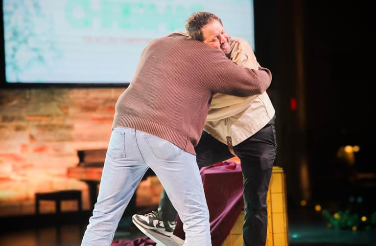 Farrell Dillon hugging an audience volunteer on stage